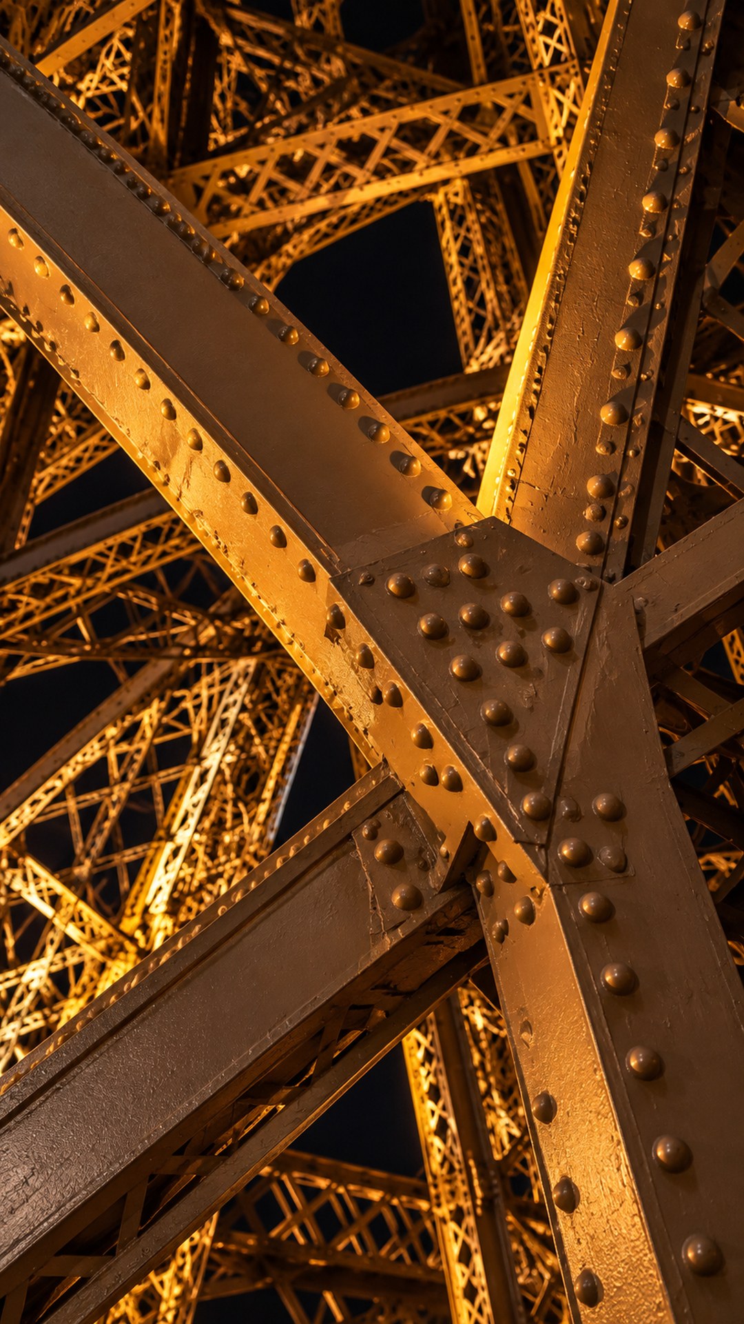 A close view of riveted metal beams in golden evening light